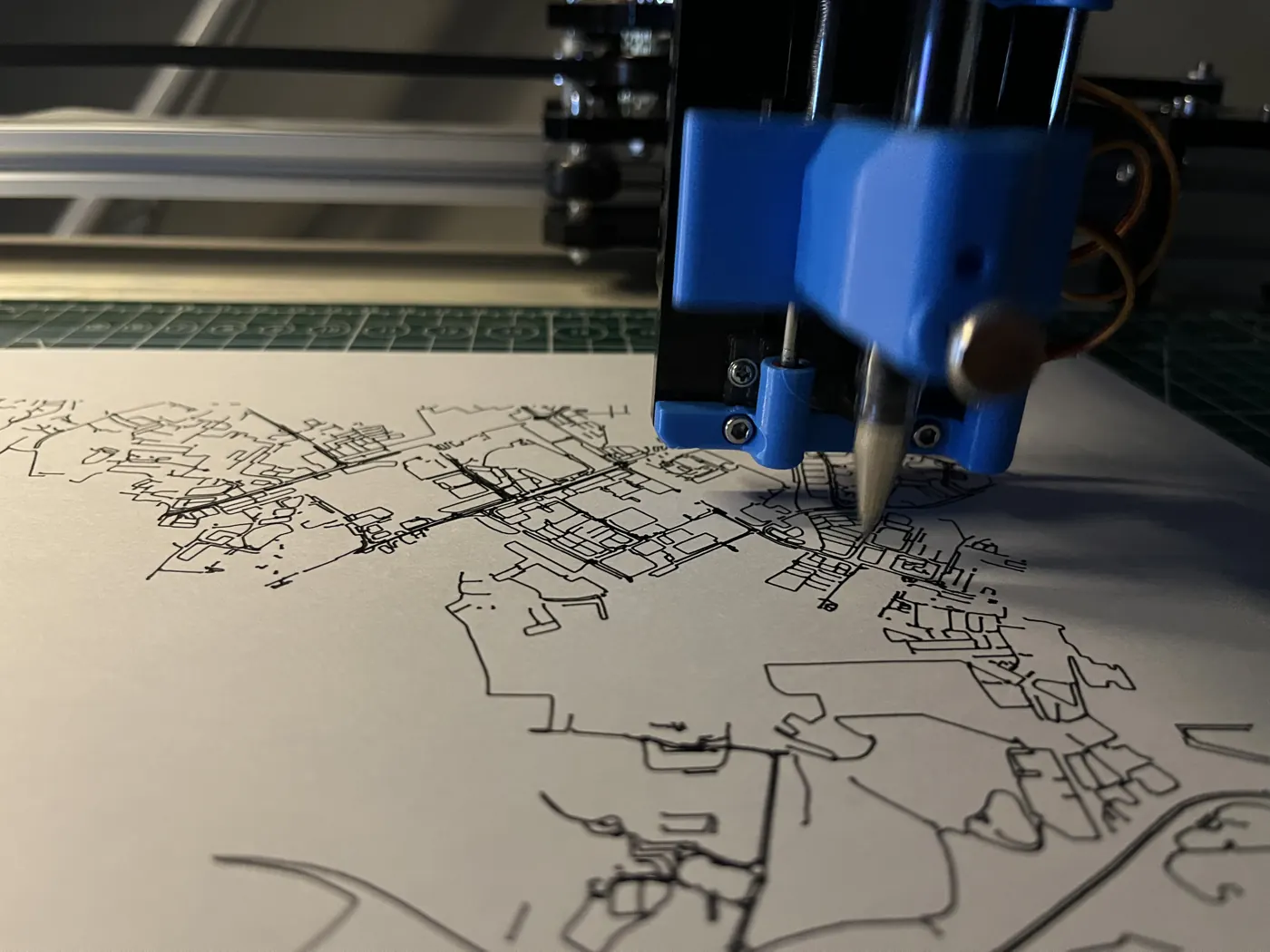 Close-up of the pen tip laying down fine road lines on the paper.